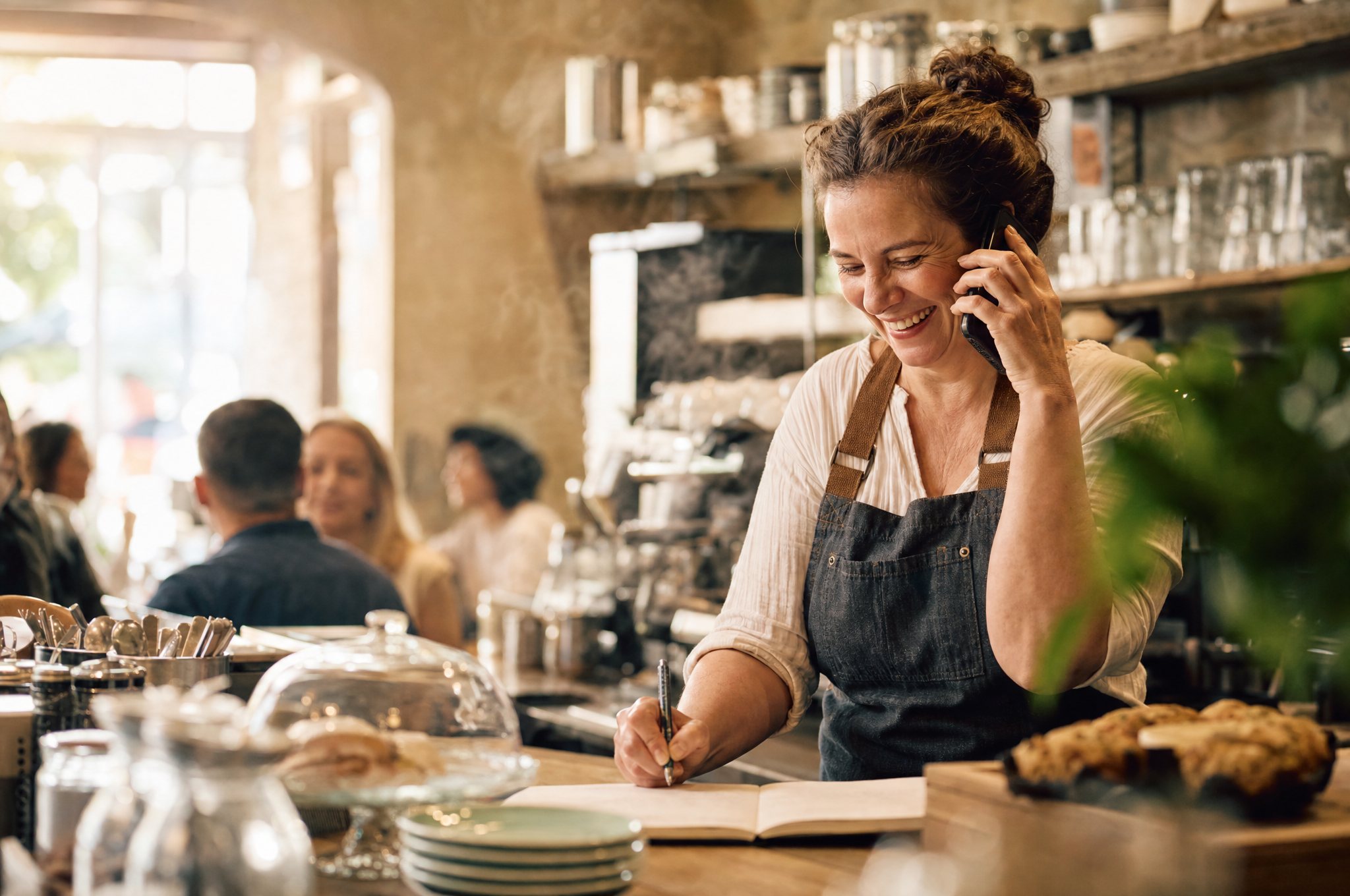 Australian cafe owner taking a booking over the phone